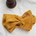 Macro view of a textured mustard yellow ribbed cotton wide bow headband for women - Ginger Yellow