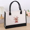 Macro view of the cute reindeer cartoon print on the durable cream canvas tote bag. - Deer