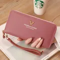 Elegant mauve litchi texture long zipper wallet with gold deer emblem held by hand - Long Zipper Clutch (PG401) / Deep Pink