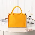 Bolso tote moderno de yute y lona amarilla con acabado texturizado en ambiente hogareño. - Amarillo