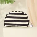 Stijlvolle gestreepte canvas make-uptas in halve maanvorm met decoratieve pompons - Zwart-witte Strepen