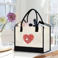 Canvas tote bag with floral heart print filled with everyday essentials on a table - Rose Heart