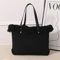 Detalle del bolso tote de lona negra con elegantes flecos y detalles de tachuelas - Negro