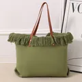 Vista detallada de un gran bolso tote tejido verde con flecos y correas de color marrón - Verde