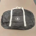 Large capacity black waterproof foldable travel duffel bag featuring a circular airplane logo - Round Label Gen 2 / Black