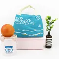 Portable blue insulated lunch bag featuring white cloud patterns and white wave designs - Sea World-Blue
