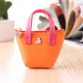 Vue détaillée d'un mini porte-monnaie orange avec poignées roses et un pendentif ours mignon - Orange