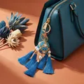 Close-up detail of a blue hydrangea tassel charm with pearls on a teal luxury handbag - Keychain / Blue