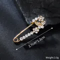 Close-up of gold alloy rhinestone safety pin brooch with size and weight specs - 3.7cm x 1.3cm