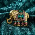 Vintage gouden olifant broche met smaragdgroene en roze strassteentjes op groen fluweel. - Antiekgoud Olifant