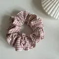 Close-up view of a pink gingham checkered scrunchie featuring elegant pressed edge details - Small Pink White Plaid Scrunchie / Pink