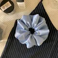 Detailed shot of a light blue satin scrunchie featuring an elegant large pleated texture design - Large Scrunchie / Light Blue