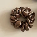 Close-up van een bruine satijnen scrunchie met glanzende en elegante strass-steentjes - Kleine Strass Scrunchie (1#) / koffiekleur