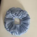 Detailed view of light blue shimmering pleated fabric scrunchie with soft texture - Ruffled Scrunchie / Blue