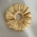 Detailed close-up showing the shimmering pleated texture of this beige floral scrunchie - Ruffled Scrunchie / Yellow