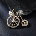 Close-up of elegant gold-toned bicycle brooch with sparkling rhinestones - Bicycle