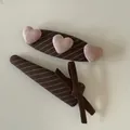 Close-up detail of stylish brown fabric hair clips featuring pink plush hearts and a ribbon bow - Coffee Striped Three Pink Hearts Hair Clip / One Pair
