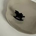 Détail d'une pince à cheveux vintage en acétate en forme de cheval noir sur un plat. - Design de cheval en bois / Pince Cheval Noire
