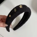 Detailansicht eines schwarzen Plüsch-Stirnbands mit goldenem Pferd und Glücksmünzen - Haarreif Pferd (2#) / Schwarz