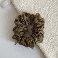 Close-up of yellow checkered fabric scrunchie with high-quality texture details. - Yellow-Black Striped Scrunchie
