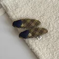 Close-up of plaid fabric hair clips with blue heart detail on textured background - Yellow Striped Oval Hair Clips (Pair)