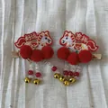 Gros plan de barrettes à cheveux rouges de l'année du cheval avec broderie et clochettes - Style Cheval Rouge Double Pompon / Ensemble de 2 Pièces