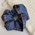 Close-up detail of a blue denim and purple plaid fabric scrunchie hair accessory - Purple Edge Blue Scrunchie