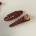 Detailed shot of burgundy striped fabric BB hair clips with cute bear and button charms - Red Striped Bear Hair Clips (Pair)