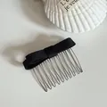 Close-up detail of a minimalist black satin bow hair comb with silver metal teeth. - Black Bow Hair Comb