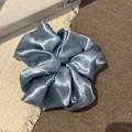 Gedetailleerd overzicht van een lichtblauwe satijnen scrunchie met delicate strasaccenten - Grote Strass Scrunchie (12#) / Blauw