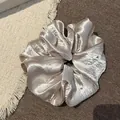 Gedetailleerd zicht op champagne parelmoer satijnen scrunchie met glanzende steentjes - Grote Strass Scrunchie (13#) / Broken Wit