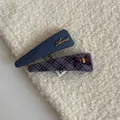 Close-up of stylish denim and purple plaid fabric hair clips on soft white fabric - Blue-Purple Striped Triangle Hair Clips (Pair)