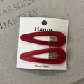 Zwei rote tropfenförmige BB-Haarspangen auf einer weißen Displaykarte mit Hanns-Markenlogo. - Acryl Wassertropfen Haarnadel (23#) / Ein Paar / Rot
