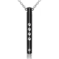 Detailed macro view of black cylindrical pet cremation urn pendant featuring white paw prints - Black Paw Print Cylinder Style