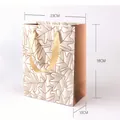 Eleganter weißer Geschenkkarton mit goldenem Glitzerblattmuster und Bandgriffen. - Dichte Blätter Stil (JD-0318) / 18x23x10cm