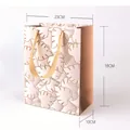 Premium rosa Geschenktüte aus Papier mit goldenem Monstera-Blattmuster, 23x18x10cm - Fensterblatt-Stil (JD-0318) / 18x23x10cm