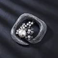 Antike silberne Brosche mit Perle und Strassblumen auf dunklem strukturiertem Hintergrund - Quadratische Blume