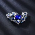 Vintage Silberbrosche mit blauen Kristallsteinen auf elegantem dunklem Satinhintergrund - Altsilber, Dunkelblau