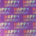 Nahaufnahme von regenbogenfarbenem „Happy Birthday“-Text auf lila Geschenkpapier. - Lila Regenbogen Party / 0.43*3m