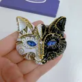 Close-up detail of a vintage cat head brooch with black and white enamel and blue eyes - Antique Gold, Black & White Fox Head
