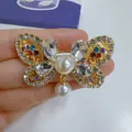 Close-up detail of an elegant vintage butterfly brooch with colorful crystals and pearls. - KC Gold, Colorful Bow