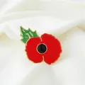 Close-up of a vintage red poppy enamel brooch on white fabric background. - KC Gold Poppy