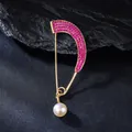 Detailed view of safety pin brooch with pink rhinestones and a white pearl charm - Fuschia