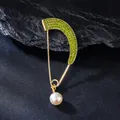 Macro detail of gold arc brooch with green rhinestones and pearl pendant. - Olive Green