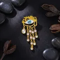 Elegante vintage gouden boze oog kwastje broche met sprankelende kristallen accenten - Goudkleur Boze Oog