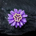 Primer plano de un elegante broche de margarita morada con centro de pedrería brillante - Estilo Margarita / Violeta Claro