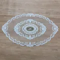Detailed view of an oval lace doily with intricate floral embroidery on a wood surface. - 44*71cm / White
