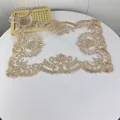 Vista dettagliata di un'elegante tovaglietta in pizzo beige con ricami floreali. - 30x43cm / Cammello