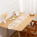 Detail view of an elegant white hollow lace table runner on a rustic wooden dining table - 30*100cm / Pure White