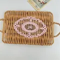 Close-up of pink embroidered lace doily with floral pattern on a wicker tray - 17*24cm / Pink